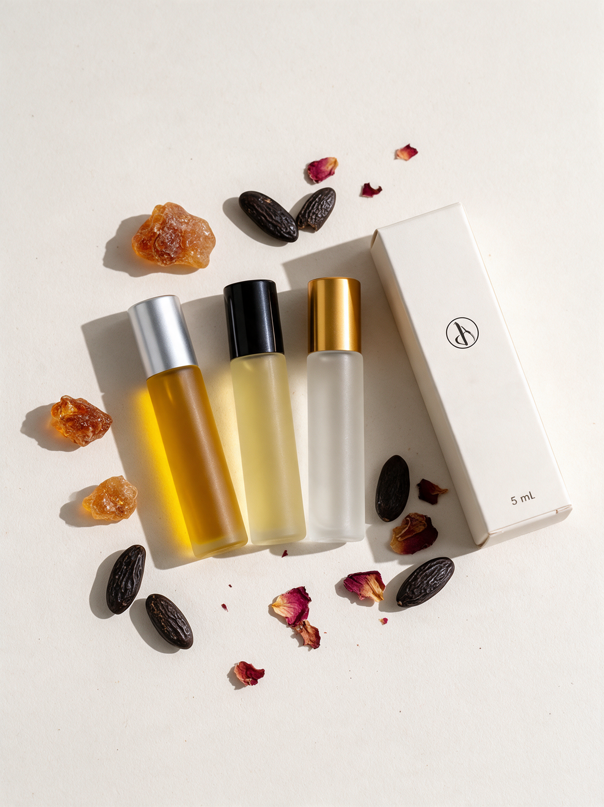 Misk Roll-On Set 3 × 5 ml Flatlay mit Amber, Tonka und Rosenblättern
